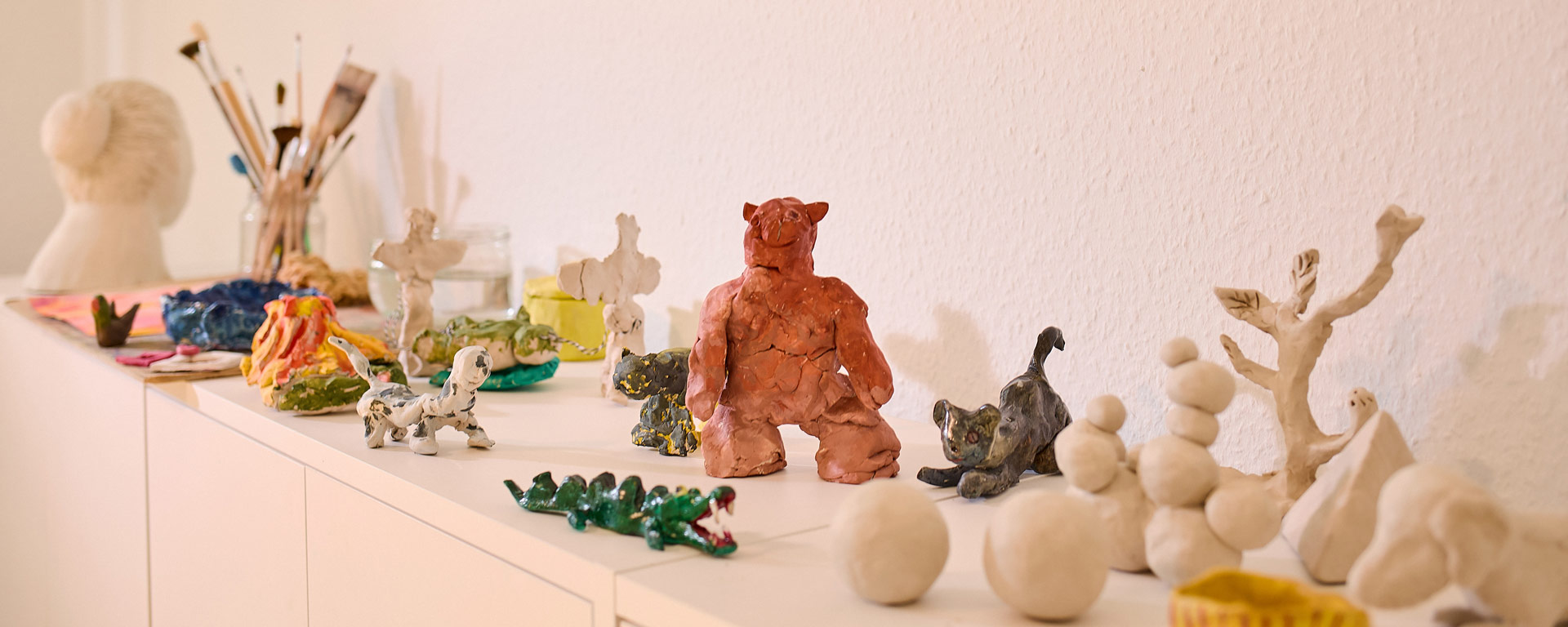 Kunsttherapeutische Tonfiguren im Regal